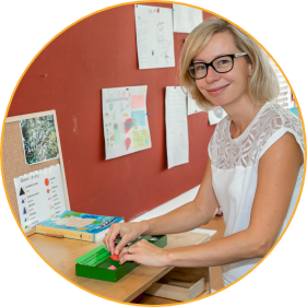 Montessori guide in a Montessori classroom with a Montessori material